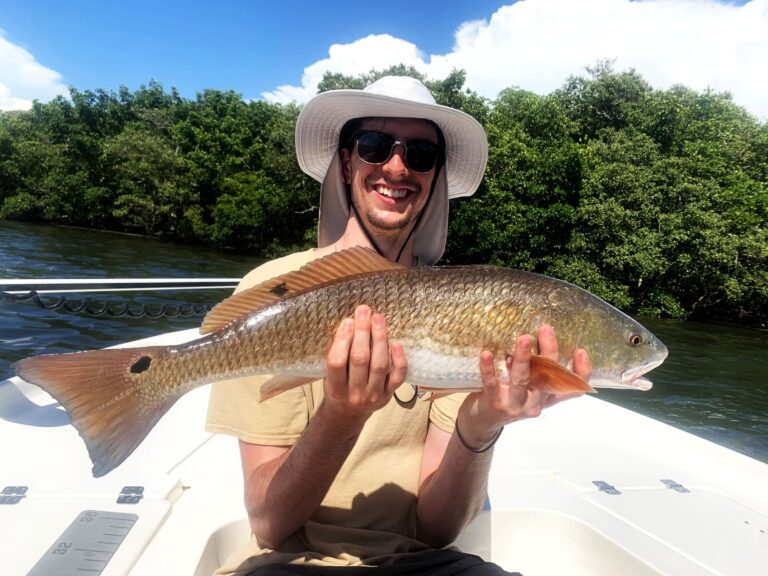Angler with a redfish over turquoise water