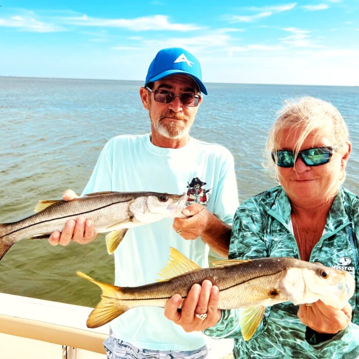 A couple holding a snook