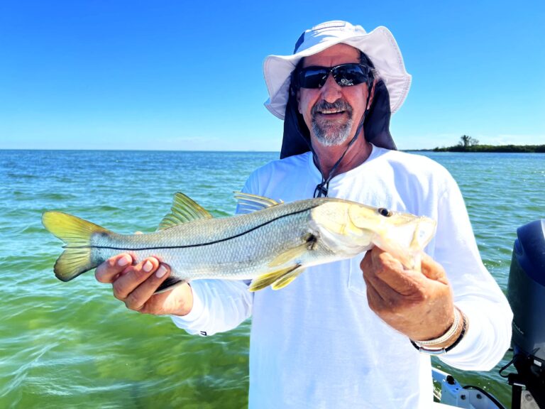 Captain Gavin holding a snook over the Tampa Bay flats
